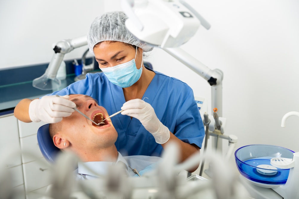 Female dentist examining oral cavity of patient as part of periodontist marketing and clinical dental care content