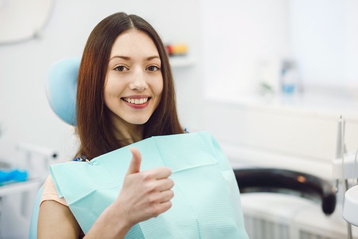 Girl showing thumbs up at dental reception representing general dentist marketing and patient satisfaction